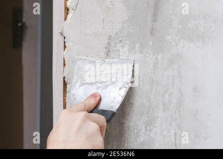 Der Mann verputzte die Wände im Raum. Nahaufnahme. Stockfoto