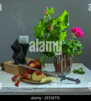 Stillleben mit Äpfeln, blühenden Geranien und erloschter Kerze. Vintage. Retro. Stockfoto