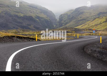 Eine ikonische isländische Straße schlängelt sich durch eine mystische Landschaft und Schließlich in einen Canyon Stockfoto