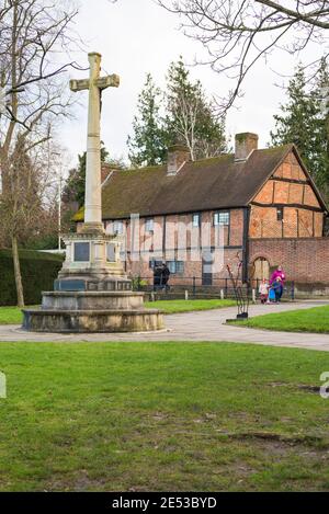 Ruislip-Kriegsdenkmal mit den Almosenhäusern aus der Tudor-Zeit im Hintergrund. Ruislip, Middlesex, England, Großbritannien Stockfoto