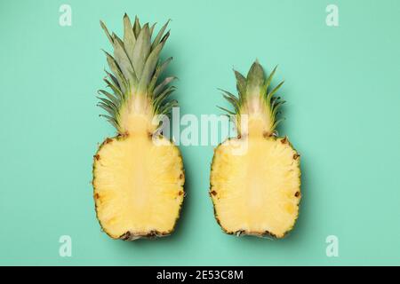 Hälften von leckeren reifen Ananas auf Minze Hintergrund Stockfoto