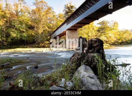 Cleveland, Alabama/USA - Okt 17, 2020: Lange Exposition des malerischen Black Warrior River und Swann Covered Bridge spät an einem warmen Herbsttag. Stockfoto