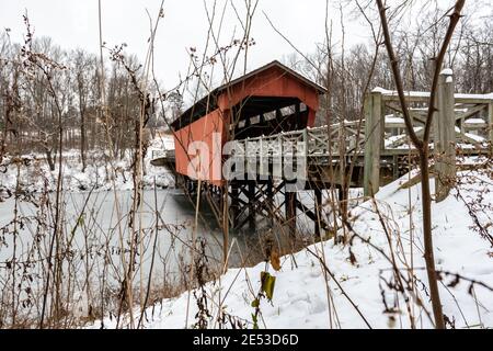 St. Clairsville, Ohio/USA - 15. Januar 2019: Schneebedeckte, historische Shaeffer Campbell Covered Bridge als Schuss durch das Unkraut und prahlte über das Verbot Stockfoto