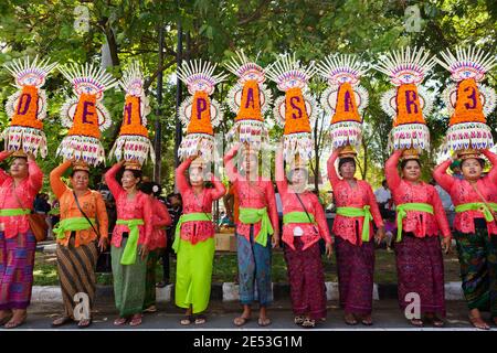 DENPASAR, BALI INSEL, INDONESIEN - 10. JUNI 2017: Gruppe von schönen Frauen in traditionellen balinesischen Kostümen führen auf Kopf religiöse Opfer Stockfoto