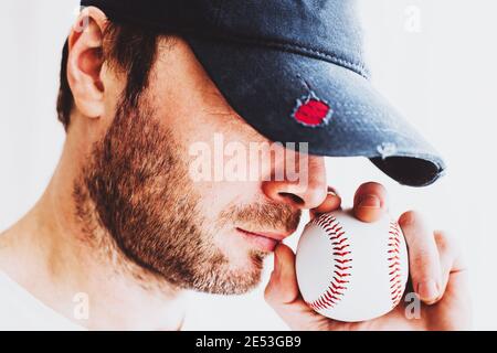 Baseball-Veteran mit Traurigkeit und Sehnsucht quetscht den Ball mit Seine Hand inhaliert den Geruch des Spiels - Alter Baseballkrug Stockfoto