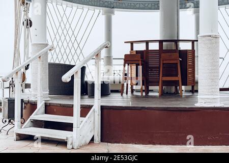 Holzstühle und Sofa auf der Außenterrasse des Hotels Stockfoto
