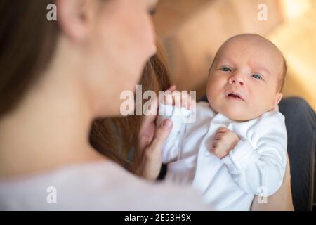 Liebevolle Mutter Cuddling Baby Sohn Auf Sofa Zu Hause Stockfoto