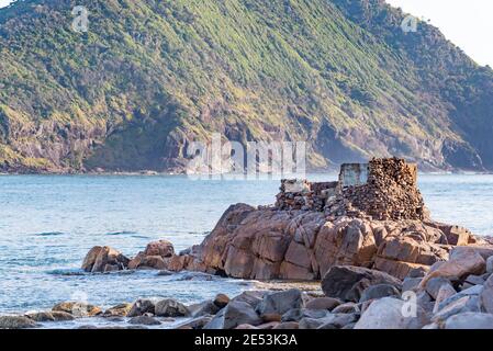 Mit Mount Yacaaba im Hintergrund, fangen die Überreste eines Weltkrieges zwei Geschützenlager das Morgenlicht am Eingang zu Port Stephens Stockfoto