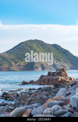 Mit Mount Yacaaba im Hintergrund, fangen die Überreste eines Weltkrieges zwei Geschützenlager das Morgenlicht am Eingang zu Port Stephens Stockfoto
