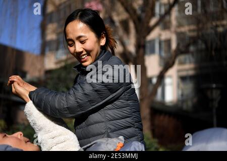 (210126) -- HEFEI, 26. Januar 2021 (Xinhua) -- Liu Ning streckt die Arme ihres Freundes Peng Yalou in Hefei, ostchinesische Provinz Anhui, 13. Januar 2021. Peng Yalou ist seit mehr als drei Jahren nach einem Unfall im Jahr 2017 im Koma. Seine Freundin Liu Ning ließ ihn nicht und entschied sich zu bleiben und sich um ihn zu kümmern. Um Muskelatrophie aufgrund jahrelanger Inaktivität zu verhindern, massiert Liu ihn regelmäßig von den Armen bis zu den Füßen und hilft ihm beim Rehabilitationstraining. Unter der sorgfältigen Pflege von ihr erholt sich Peng allmählich und gewinnt das Bewusstsein. Sie glaubt, dass Wunder geschehen würden, und hofft auf Peng Stockfoto