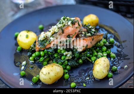 Lachsfilet mit grünen Erbsen und Spinat Stockfoto