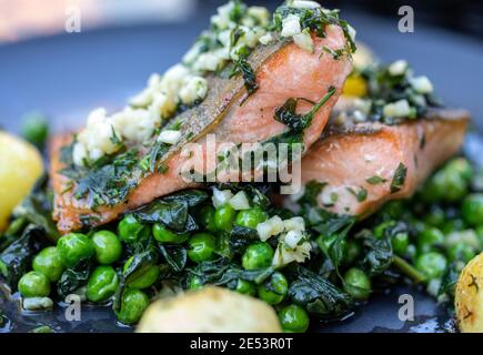 Lachsfilet mit grünen Erbsen und Spinat Stockfoto