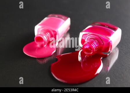 Beauty Hintergrund zwei Flaschen Nagellack-Flaschen rot oder burgunderrot pink Spill gegossen auf dem Tisch auf einem schwarzen Hintergrund mit einem Copyspace . Stockfoto