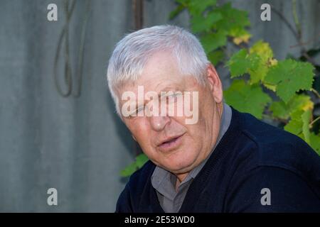 Der alte grauhaarige Mann schaut nicht auf die Kamera. Stockfoto