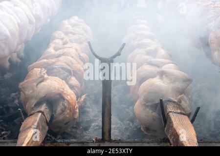 Hühner kochen auf einem Grill mit langsam rotierenden Spießen, Spieße. Stockfoto