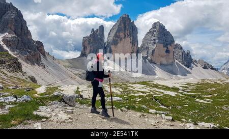 Junge Wanderin, die vor den herrlichen Berggipfeln der Tre Cime di Lavaredio, Italien, steht. Stockfoto