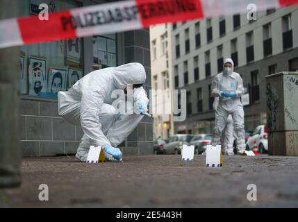 26. Januar 2021, Hessen, Frankfurt/Main: Offiziere der Forensik sichern auf dem Bürgersteig in der Niddastraße Blutspuren. Bei einem mutmaßlichen Messerangriff wurden heute Morgen mehrere Personen verletzt. Ein Polizeisprecher sagte, dass ein Verdächtiger festgenommen worden sei. Weitere Details, wie die Schwere der Verletzungen, waren zunächst nicht bekannt. Foto: Frank Rumpenhorst/dpa Stockfoto