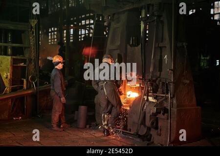 Rückansicht der Arbeiter, die in Industrieanlagen mit Metall arbeiten Stockfoto