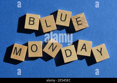 Blauer Montag, Wörter in hölzernen Buchstaben isoliert auf blauem Hintergrund Stockfoto