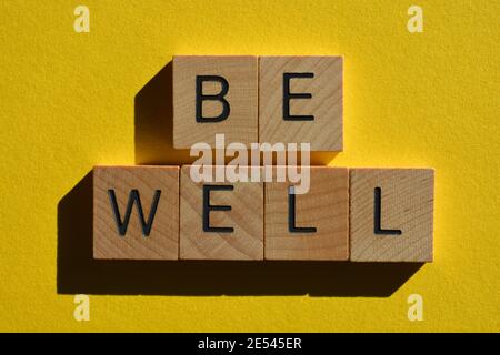 Seien Sie gut, Satz in hölzernen Buchstaben Alphabet isoliert auf gelbem Hintergrund Stockfoto