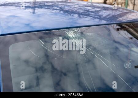 Gebrochene Windschutzscheibe mit vielen Rissen und kleinen Glasstücken, beschädigtes Auto Stockfoto