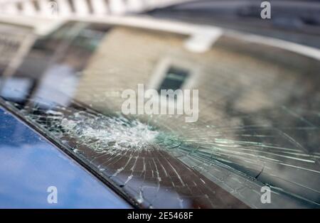 Gebrochene Windschutzscheibe mit vielen Rissen und kleinen Glasstücken, beschädigtes Auto Stockfoto