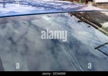 Gebrochene Windschutzscheibe mit vielen Rissen und kleinen Glasstücken, beschädigtes Auto Stockfoto