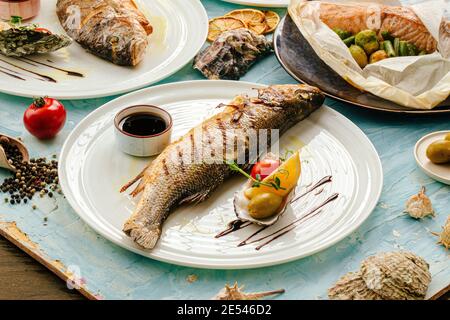 Gourmet gegrillter Seebarsch Fisch auf dem Tisch serviert Stockfoto
