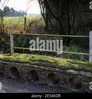 Entwässerungsrohre in einer Fußgängerbrücke, die eine furt an Carter's Bridge, Lower Rudge, Wiltshire, England, UK überquert. Stockfoto