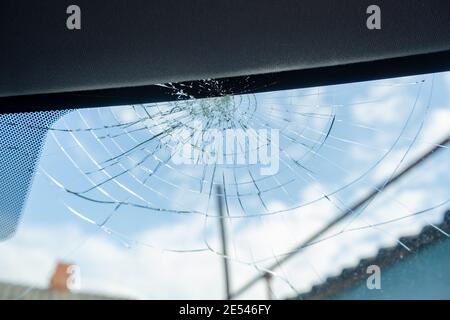 Gebrochene Windschutzscheibe mit vielen Rissen und kleinen Glasstücken, beschädigtes Auto Stockfoto
