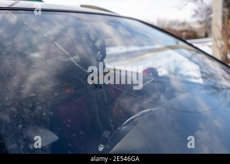 Gebrochene Windschutzscheibe mit großem Riss durch das Glas, beschädigtes Auto Stockfoto