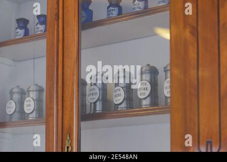 Regale mit Dosen in einer alten Apotheke. Schränke mit Glasregalen. Banken mit Medikamenten. Stockfoto