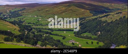 Ein breiter Panoramablick auf Swaledale, Yorkshire Dales National Park, mit dem Dorf, Wiesen und Moore von Gunnerside in der Ferne Stockfoto