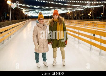 Junge Paar verbringen ihre Weihnachtsferien auf Eisbahn in Der Park Stockfoto