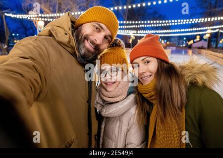 Selfie-Porträt der Familie von drei lächelt an der Kamera während Gemeinsam im Freien Schlittschuhlaufen Stockfoto