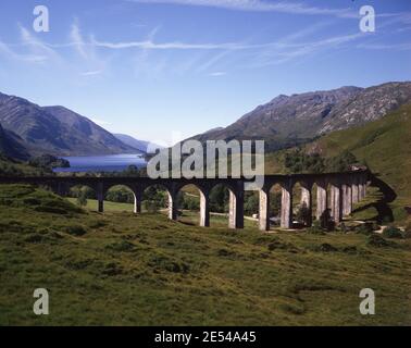 Schottland, Inverness - Shire. Ein strahlender Morgen in Glenfinnan mit nur wenigen hohen Zirruswolken über dem Viadukt. Loch Shiel, blau in der Ferne, unterstützt von Bheinn Odhar Bheag auf 2.895 Fuß. Ca. 1985. Foto von Tony Henshaw/Tom Parker Collection Gescannt von einer 5 x 4' Original-Transparenz aus einem einzigartigen und atemberaubenden Archiv von Originalaufnahmen von den Britischen Inseln vom Fotografen Tom Parker. © World Copyright. Stockfoto