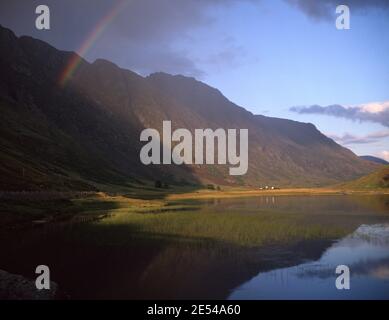 Schottland, Glencoe. Ein Regenbogenbogen über den dunklen Klippen von Aonach Eagach, während niedriges Sonnenlicht über Loch Triochatan spielt. Ca. 1981. Foto von Tony Henshaw/Tom Parker Collection Gescannt von einer 5 x 4' Original-Transparenz aus einem einzigartigen und atemberaubenden Archiv von Originalaufnahmen von den Britischen Inseln vom Fotografen Tom Parker. © World Copyright. Stockfoto