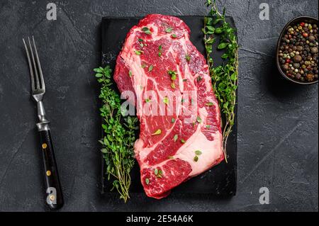 RAW Organic Chuck Eye Roll Fleisch Steak Schnitte. Schwarzer Hintergrund. Draufsicht Stockfoto