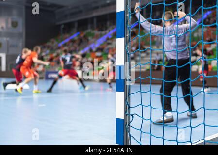 Detail der Handball Torpfosten mit Net und Handball Match im Hintergrund. Stockfoto