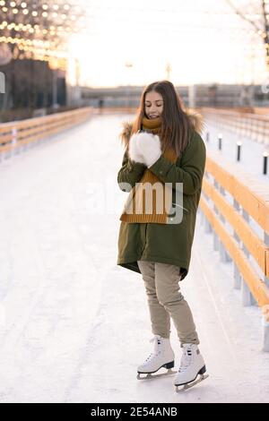 Junge Frau in Eiskunstlauf stehend auf Eislaufbahn im Freien Im Winter Tag Stockfoto