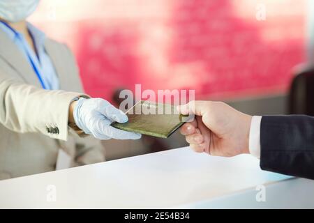 Nahaufnahme eines Mannes, der seine Dokumente zur Registrierung bei der ausgibt flughafen Stockfoto