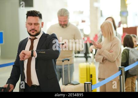 Leute mit Gepäck, die am Flughafen anstehen, um einchecken zu können Stockfoto