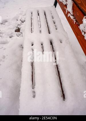 Vergessene Holzbank im Winter Park. Frischer Pulverschnee bedeckte die Sitzbank mit geringem Abstand. Stockfoto