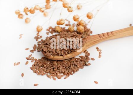 Leinsamen in einem Holzlöffel. Leinsamen und Leinsamen auf weißem Hintergrund. Gesunde Ernährung. Stockfoto