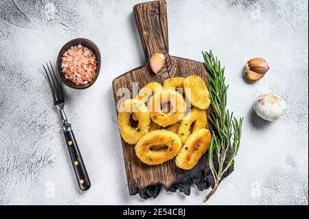 Frittierter knuspriger Tintenfisch und Zwiebelringe paniert. Weißer Hintergrund. Draufsicht Stockfoto