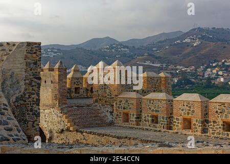 Der Blick von der teilweise restaurierten Festung und Stadtmauer der Zitadelle an der kleinen spanischen Küstenstadt Almunica, mit den Bergdörfern in t Stockfoto