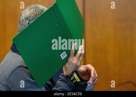 26. Januar 2021, Niedersachsen, Göttingen: Der Angeklagte steht mit grüner Mappe und Handschellen bei der Prozessauthour im Landgericht. Der Angeklagte soll seine schlafende Frau erschossen haben. Foto: Swen Pförtner/dpa Stockfoto