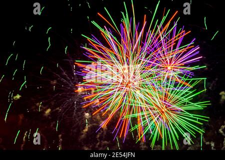 Farbenprächtiges, malerisches Feuerwerk am dunklen Himmel mit bunten leuchtenden Kugeln und flimmernden Sternen. Heller Feiertagshintergrund Stockfoto