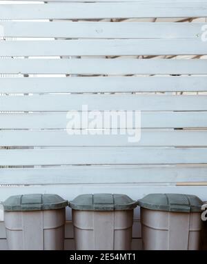 Weiße Holzplanken Hintergrund mit drei Kunststoff-Mülleimer unten, Umwelt Hintergrund Stockfoto