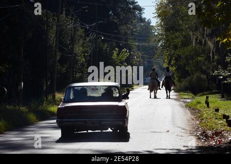 Ein Paar Gauchos auf einer gepflasterten Straße in Benavidez, Provinz Buenos Aires, Argentinien. Stockfoto